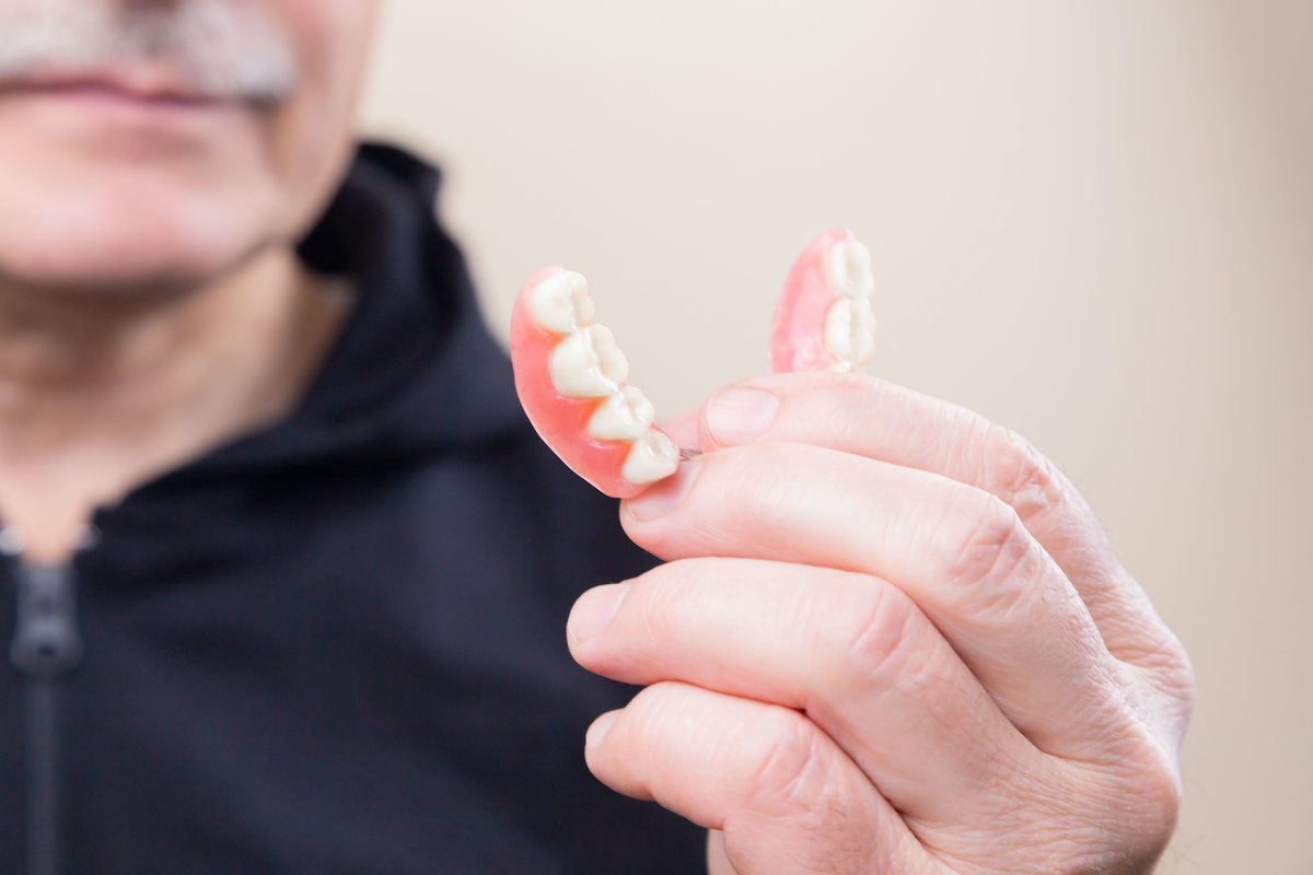 A patient holding a partial denture
